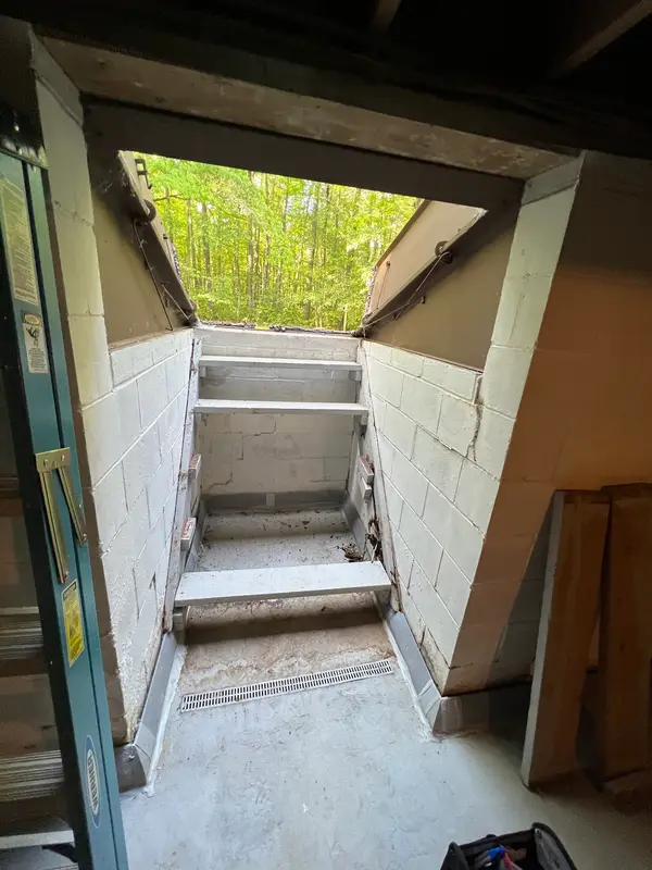 Concrete steps of the basement stairwell entry