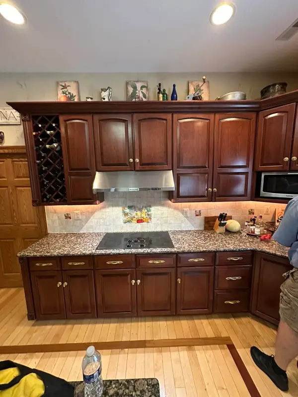 Cherry kitchen with a new stainless range hood over the cooktop