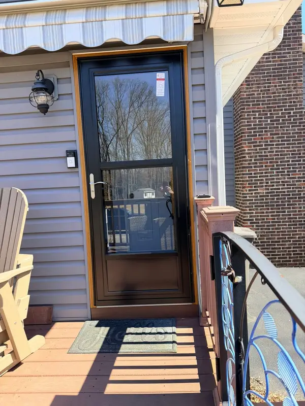 Black storm door installed on a side entry
